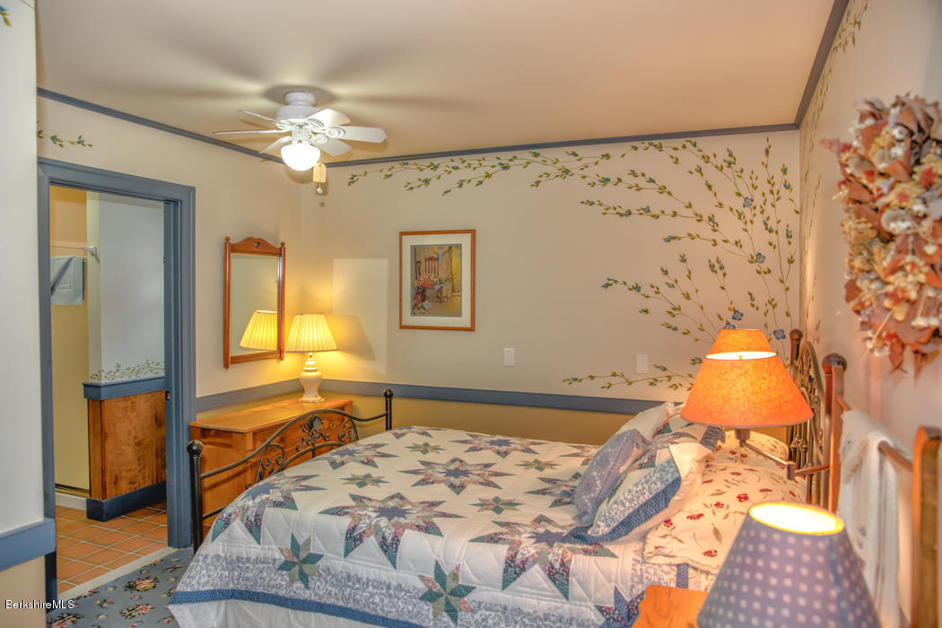 99 Kibbe Road Otis, MA 01029 - Photo 48 of 58 a bedroom with a bed and wooden floor