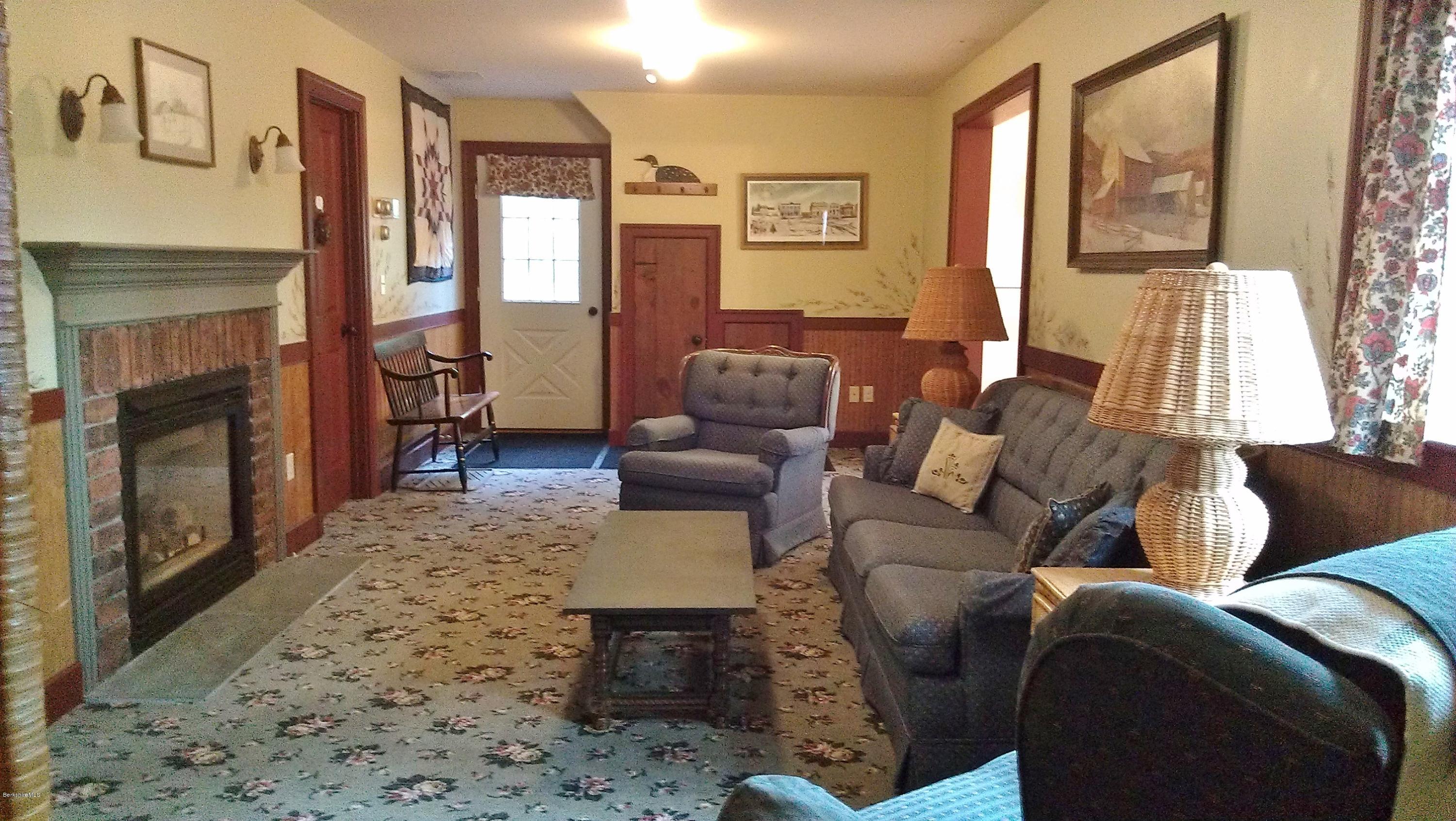 99 Kibbe Road Otis, MA 01029 - Photo 54 of 58 a living room with furniture a large window and a fireplace
