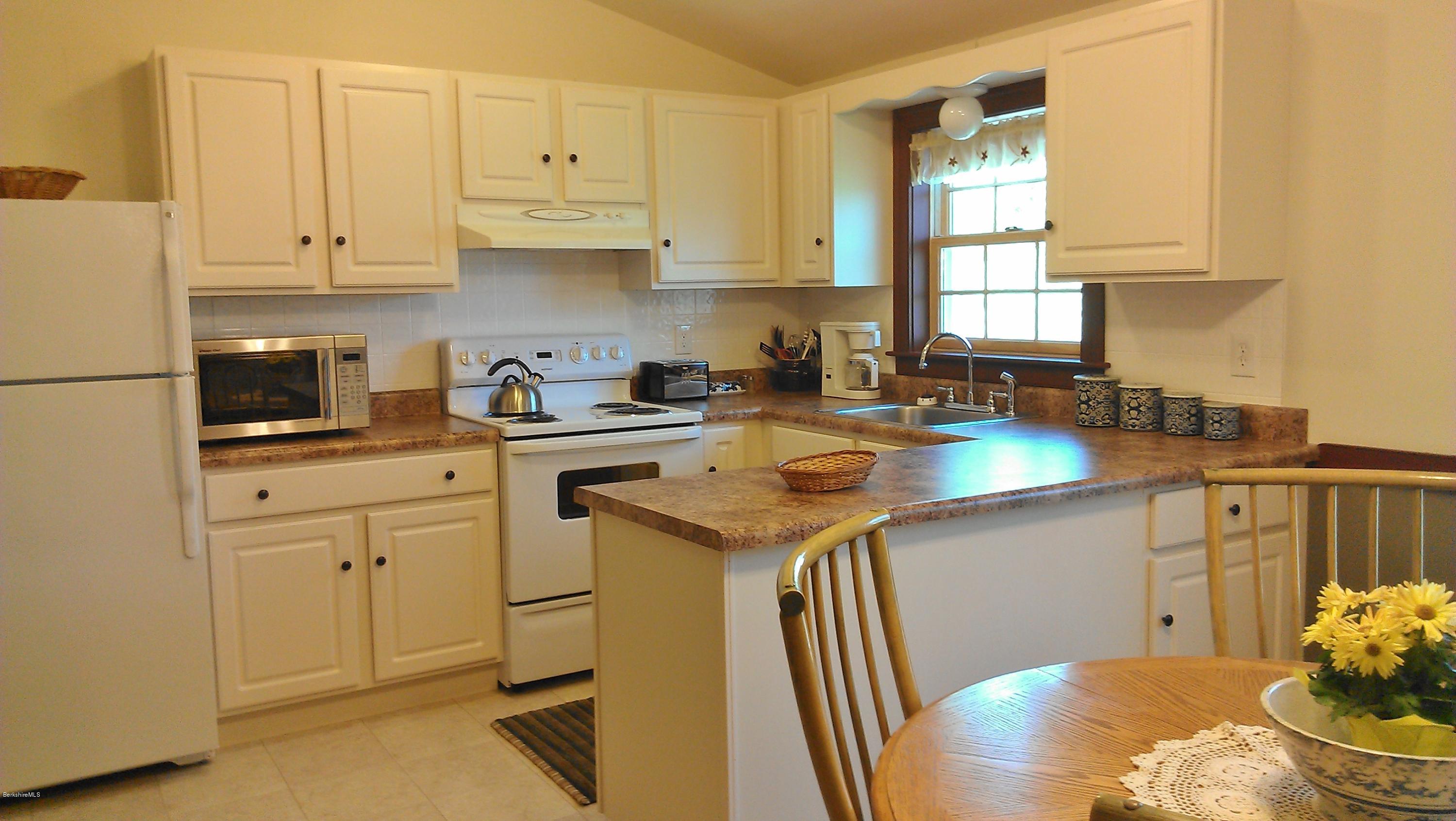 99 Kibbe Road Otis, MA 01029 - Photo 56 of 58 a kitchen with stainless steel appliances granite countertop a sink a stove and white cabinets