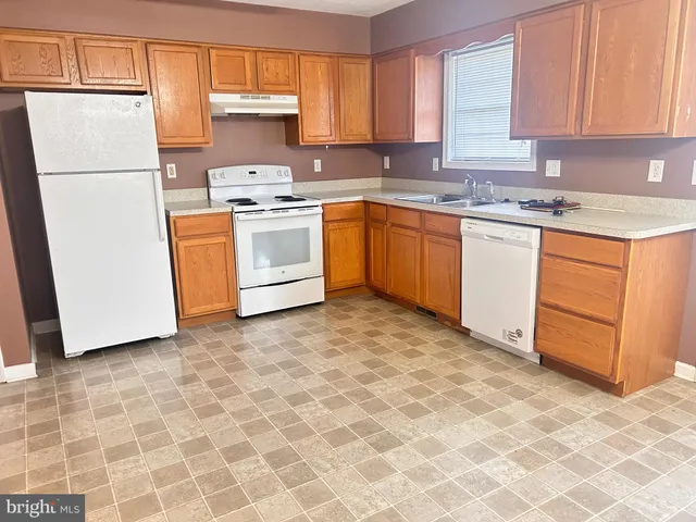 a kitchen with white cabinets sink and white appliances