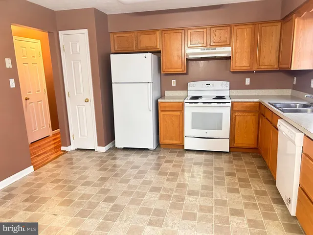 a kitchen with a stove a sink and a refrigerator