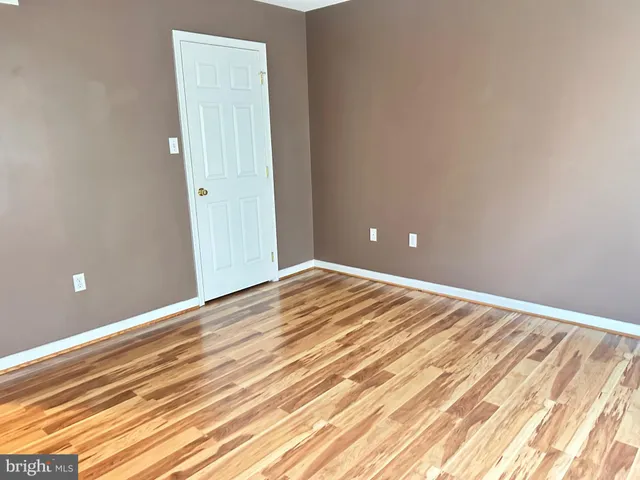 an empty room with wooden floor and sliding door
