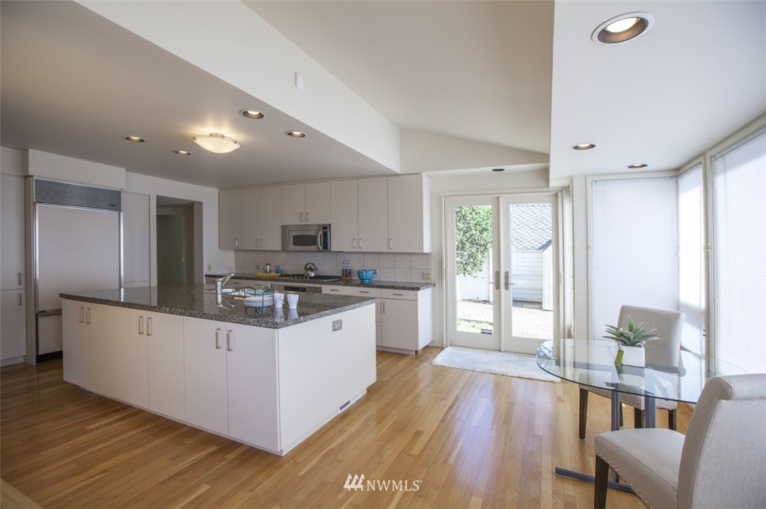 294 Briar Road Bellingham, WA 98225 - Photo 11 of 25 a kitchen with stainless steel appliances kitchen island granite countertop a stove a refrigerator a sink a dining table and chairs with wooden floor