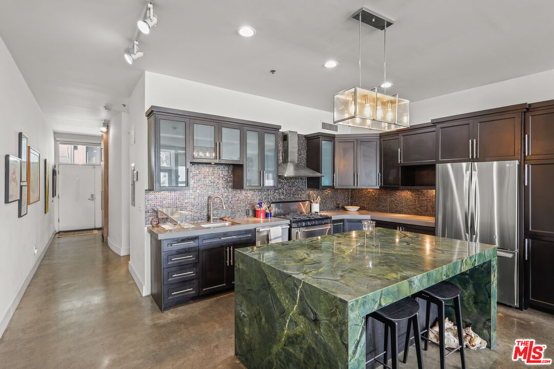615 Hampton Drive, Unit A103 Venice, CA 90291 - Photo 12 of 20 a kitchen with stainless steel appliances granite countertop a stove oven and a refrigerator