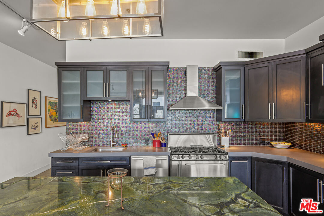 615 Hampton Drive, Unit A103 Venice, CA 90291 - Photo 13 of 20 a kitchen with kitchen island granite countertop wooden cabinets and a counter top space