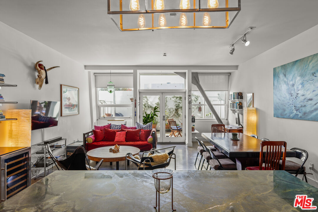 615 Hampton Drive, Unit A103 Venice, CA 90291 - Photo 14 of 20 a living room with furniture a large window and a chandelier