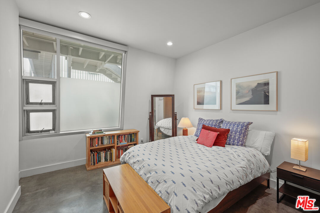 615 Hampton Drive, Unit A103 Venice, CA 90291 - Photo 7 of 20 a bedroom with a bed and a lamp on table