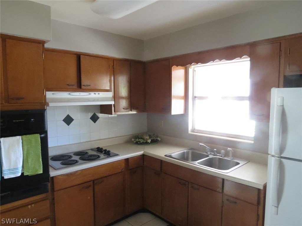302 Penn Road West Lehigh Acres, FL 33936 - Photo 2 of 10 a kitchen that has a sink and a stove