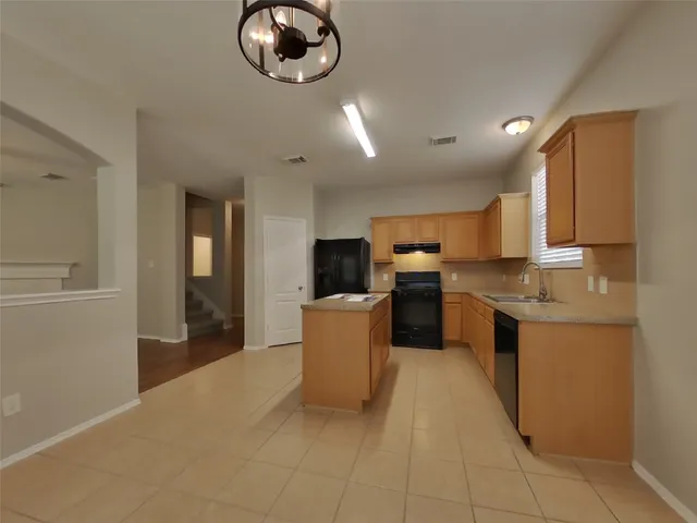 a large kitchen with a large counter top appliances and cabinets