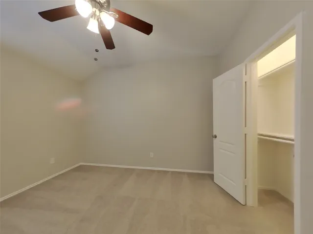 an empty room with a empty space and a ceiling fan