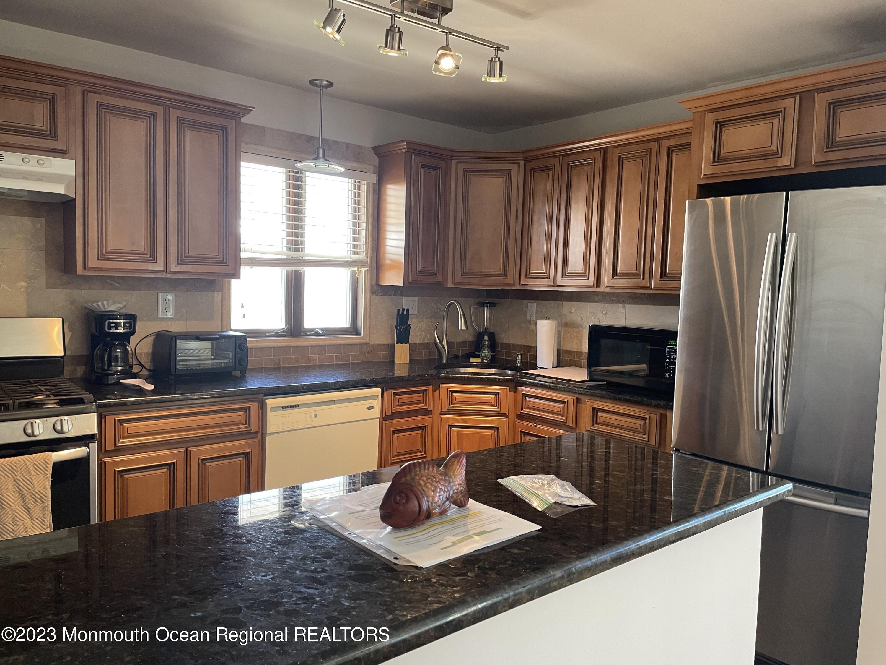 65 Grand Central Avenue Lavallette, NJ 08735 - Photo 3 of 15 a kitchen with stainless steel appliances granite countertop a refrigerator sink stove microwave and cabinets