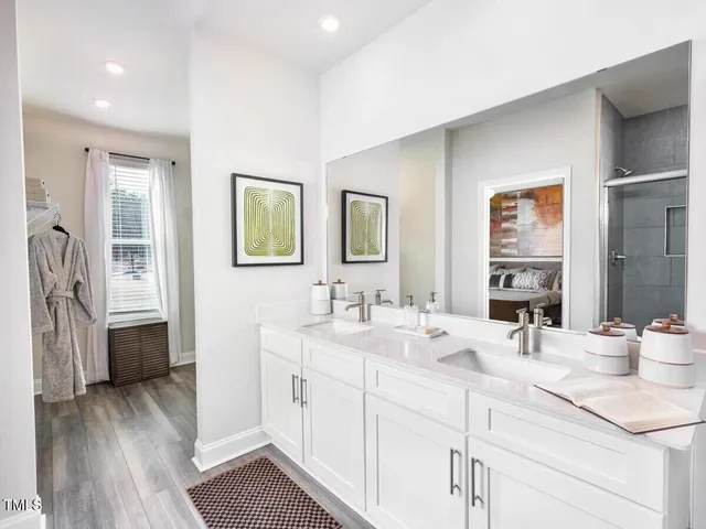 a bathroom with double vanity sink a mirror and a bathtub