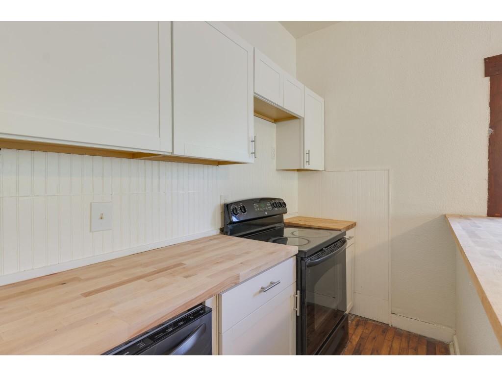 106 South Ave A, Unit A Elgin, TX 78621 - Photo 5 of 12 a kitchen with a sink cabinets and a wooden floor
