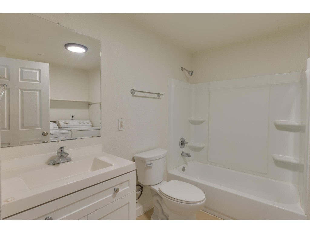106 South Ave A, Unit A Elgin, TX 78621 - Photo 8 of 12 a bathroom with a sink toilet a mirror and shower