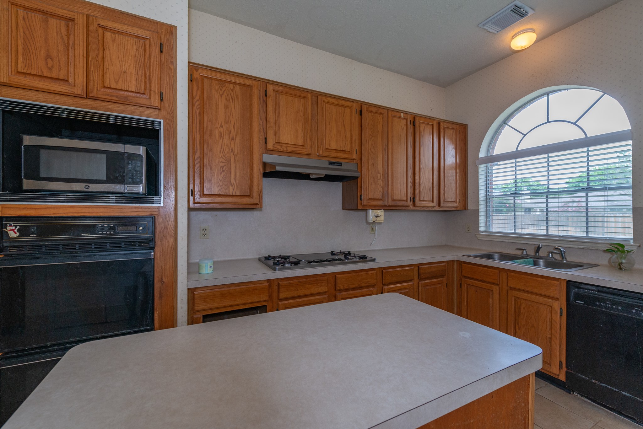 12203 Canterhurst Way Houston, TX 77065 - Photo 10 of 23 a kitchen with granite countertop wooden cabinets stainless steel appliances and a window