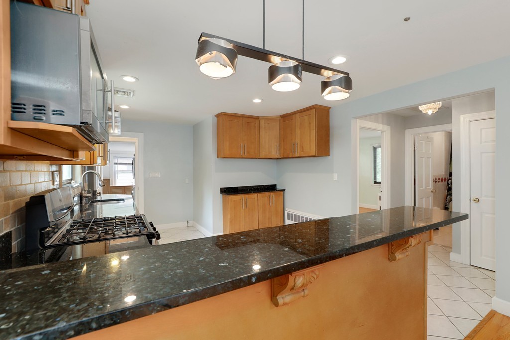 37 Louise Road, Unit 37 Newton, MA 02467 - Photo 11 of 33 a kitchen with stainless steel appliances granite countertop a sink a stove top oven a counter top space and cabinets
