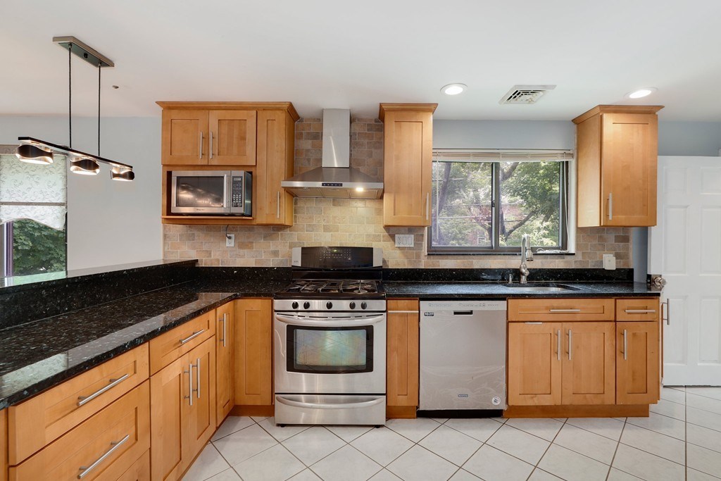 37 Louise Road, Unit 37 Newton, MA 02467 - Photo 9 of 33 a kitchen with stainless steel appliances granite countertop a stove a sink and a microwave
