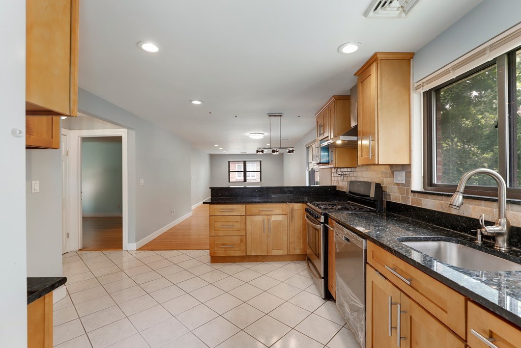 37 Louise Road, Unit 37 Newton, MA 02467 - Photo 10 of 33 a kitchen with granite countertop a sink and a stove top oven