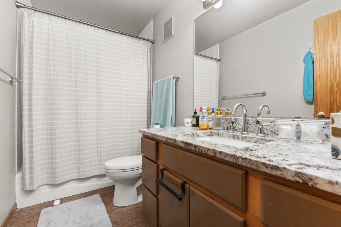 1215 Ridge View Drive Steamboat Springs, CO 80487 - Photo 17 of 30 Bathroom featuring toilet, vanity, shower / bath combo, and tile patterned flooring
