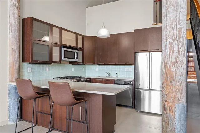 a kitchen with stainless steel appliances granite countertop a refrigerator and a microwave