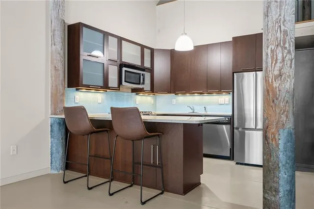 a kitchen with stainless steel appliances kitchen island granite countertop a refrigerator and a stove top oven