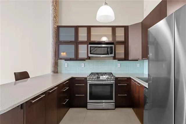 a kitchen with stainless steel appliances a stove microwave and sink
