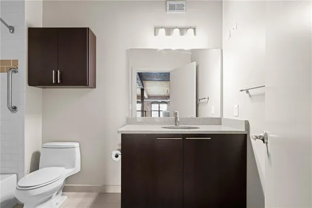 a bathroom with a granite countertop sink and a toilet