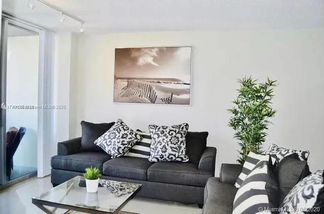 a living room with furniture and a potted plant