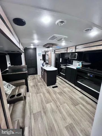 a kitchen with stainless steel appliances kitchen island granite countertop a sink dishwasher stove and cabinets