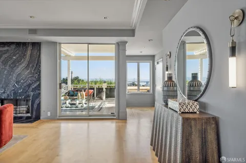 a view of a hallway with wooden floor and a fireplace