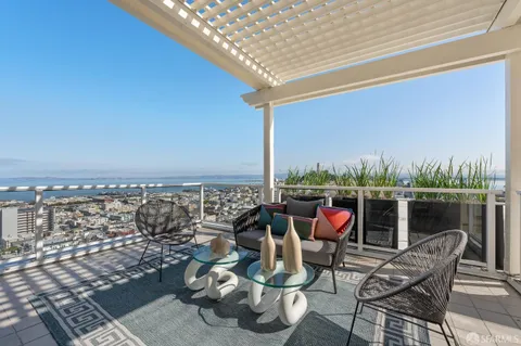 an outdoor sitting area with furniture and pool view
