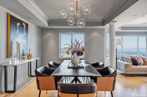 a view of a dining room with furniture a chandelier and wooden floor