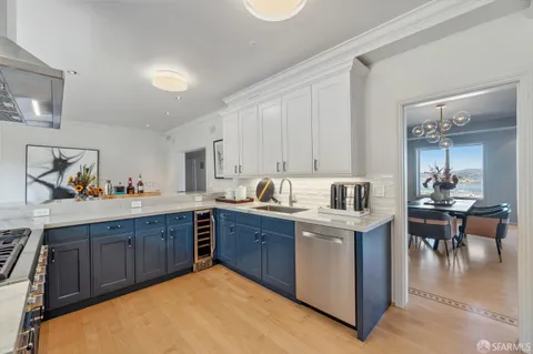 a large kitchen with stainless steel appliances granite countertop a table chairs sink and cabinets