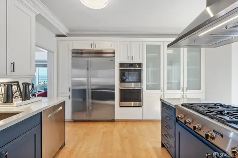 a kitchen with granite countertop a sink cabinets and stainless steel appliances
