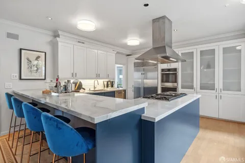 a kitchen with a stove a sink a table and chairs