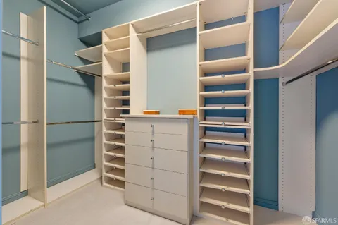 a view of walk in closet with empty racks