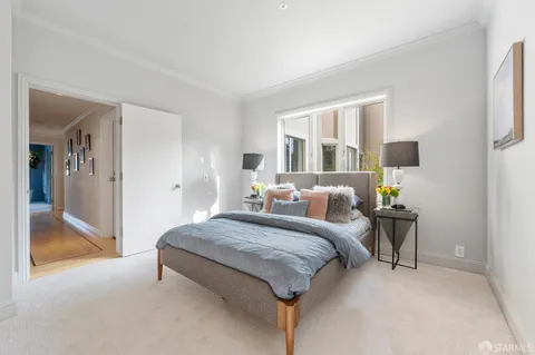 a spacious bedroom with a bed and large mirror