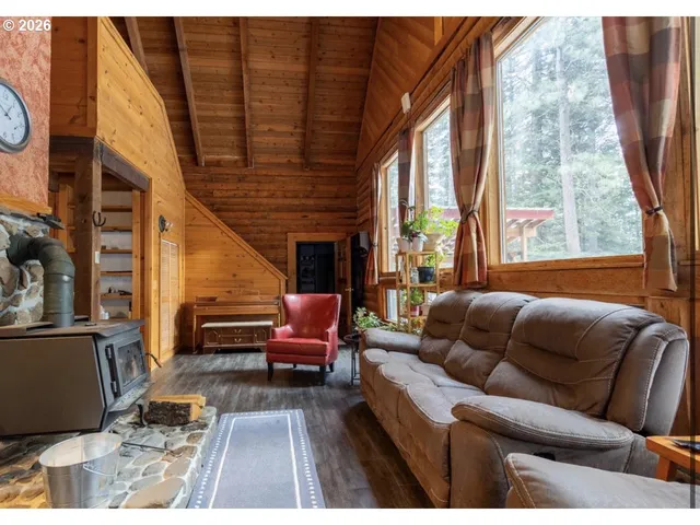 a living room with furniture a fireplace and a floor to ceiling window