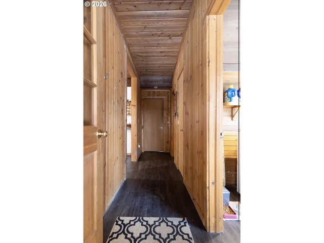 a view of wooden house with a large trees and wooden fence