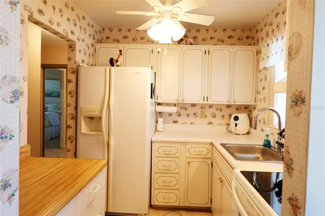 a view of a kitchen with a sink and refrigerator
