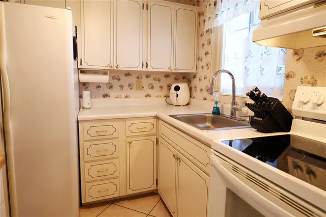 a kitchen with stainless steel appliances white cabinets and a stove top oven