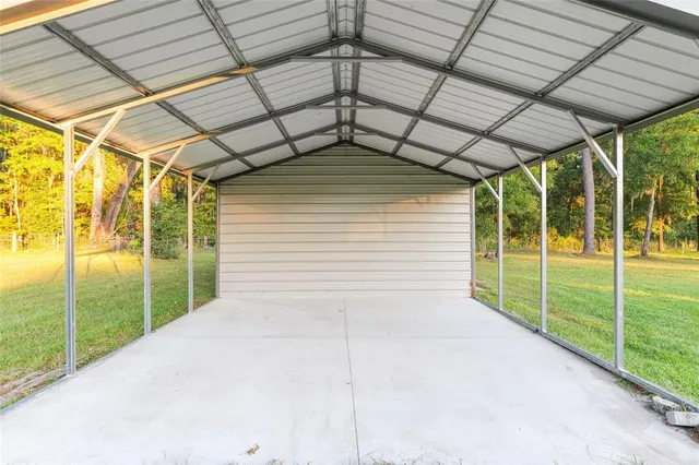 a view of a swimming pool with a lawn chairs under an umbrella