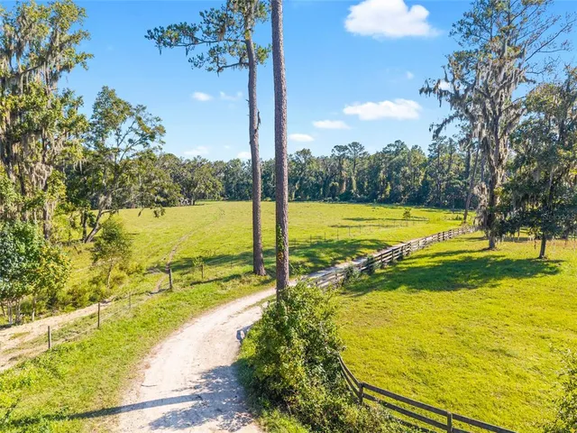 an aerial view of a house with swimming pool garden and trees