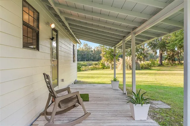 a view of a porch with chairs and backyard