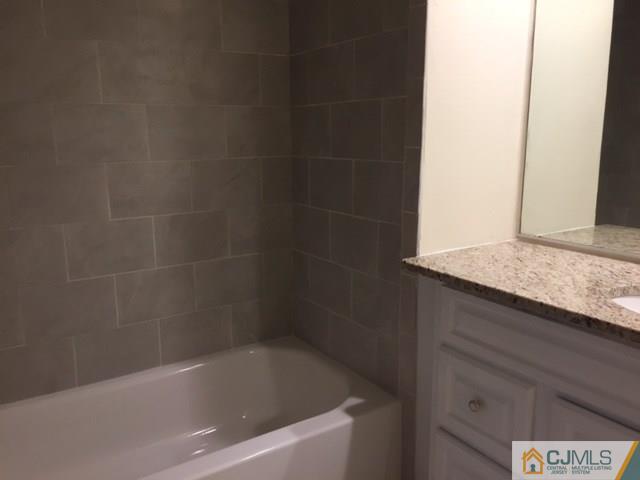 5001 Stonehedge Road, Unit 5001 Edison, NJ 08820 - Photo 12 of 13 a bath tub sitting next to a white sink