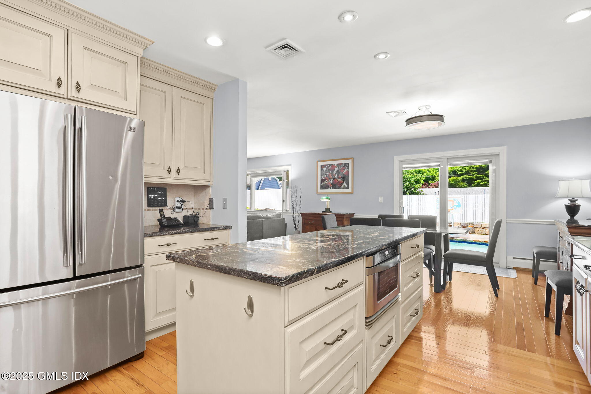16 Elizabeth Lane Riverside, CT 06878 - Photo 11 of 38 a kitchen with stainless steel appliances granite countertop a refrigerator a stove a sink a dining table and chairs
