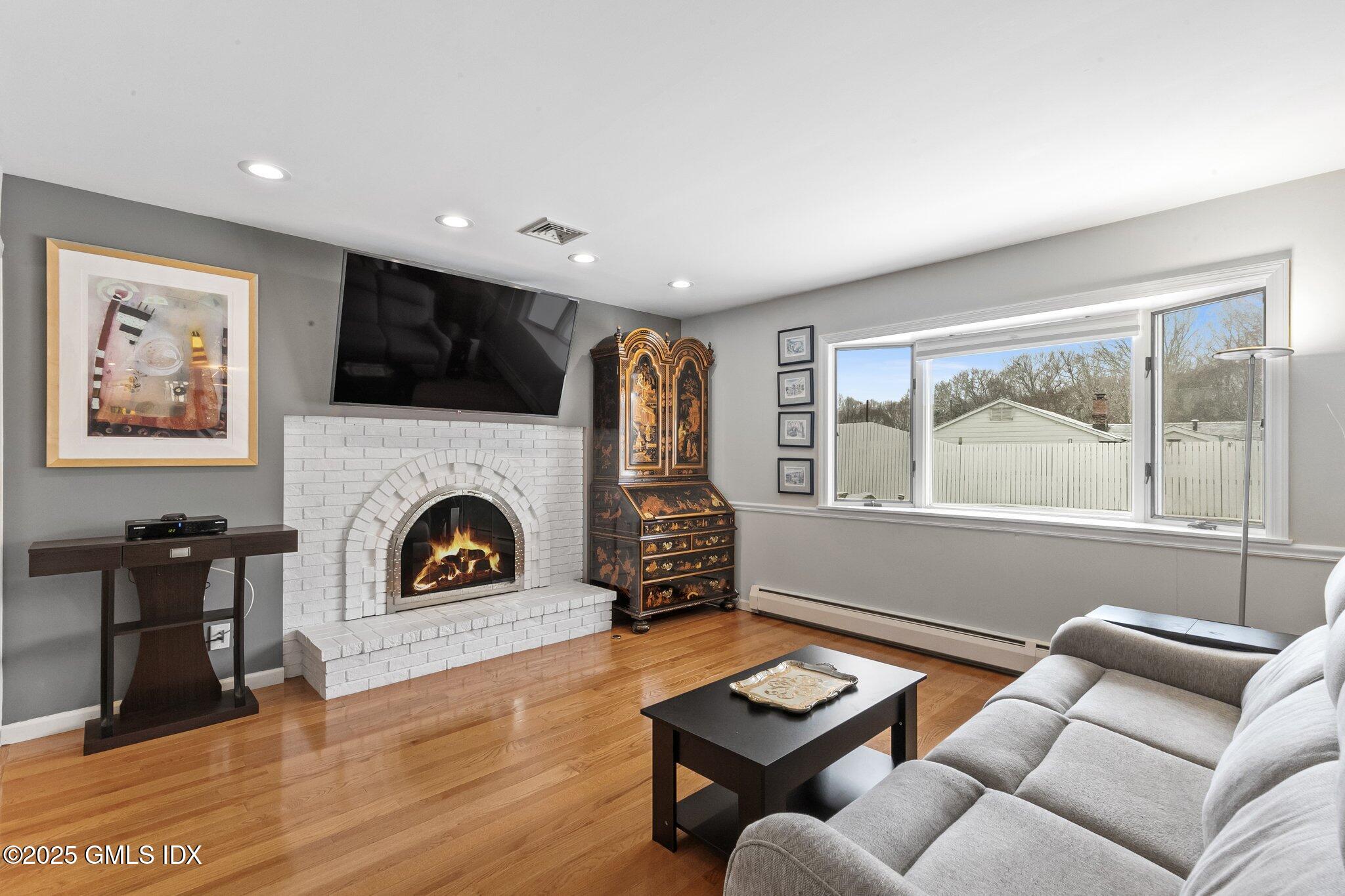 16 Elizabeth Lane Riverside, CT 06878 - Photo 2 of 38 a living room with furniture a fireplace and a flat screen tv