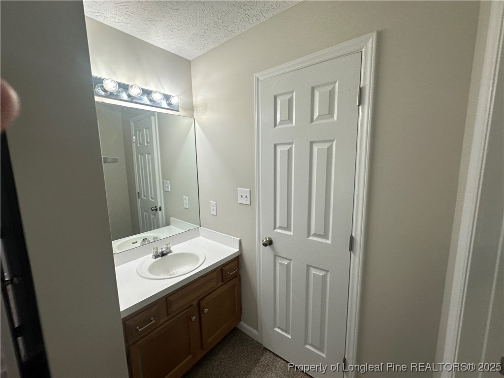 75 Tradewinds Drive Spring Lake, NC 28390 - Photo 17 of 26 a bathroom with a sink a mirror and a toilet