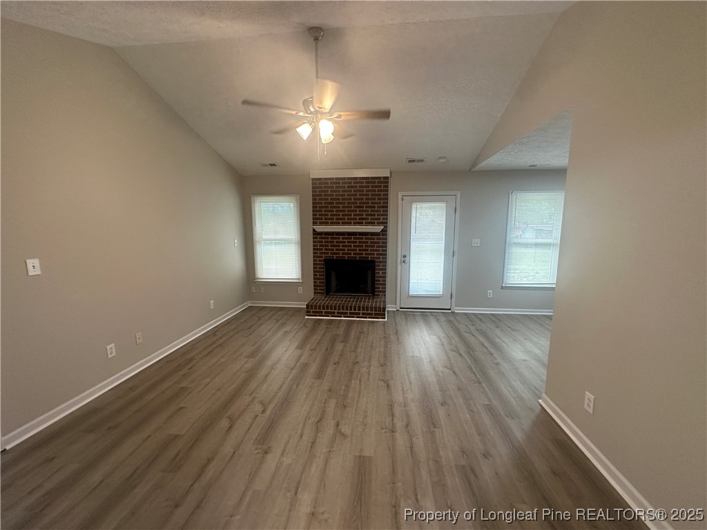 75 Tradewinds Drive Spring Lake, NC 28390 - Photo 4 of 26 an empty room with wooden floor fireplace and window