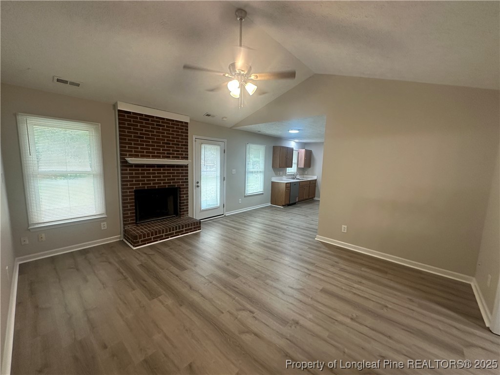 75 Tradewinds Drive Spring Lake, NC 28390 - Photo 5 of 26 an empty room with wooden floor fireplace and windows
